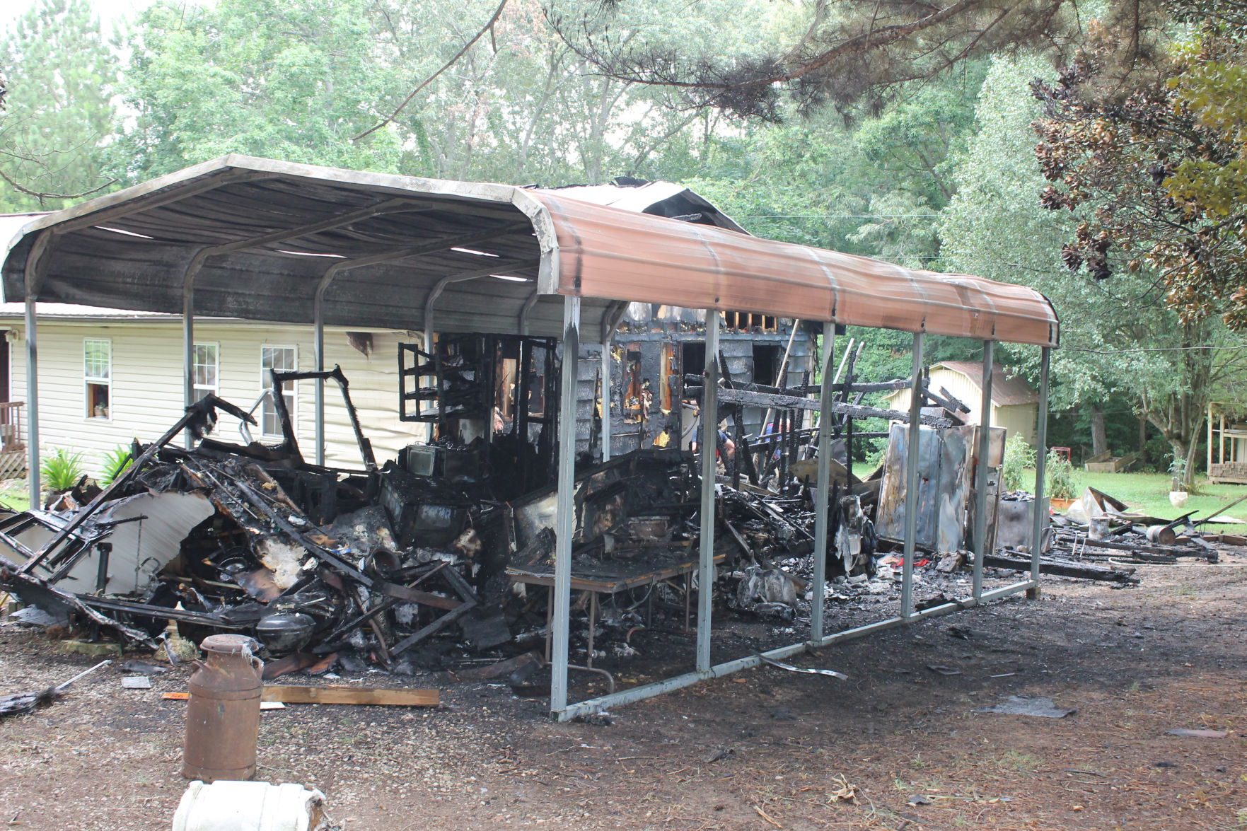 A covered carport and recreational vehicle at Meadowwood fire